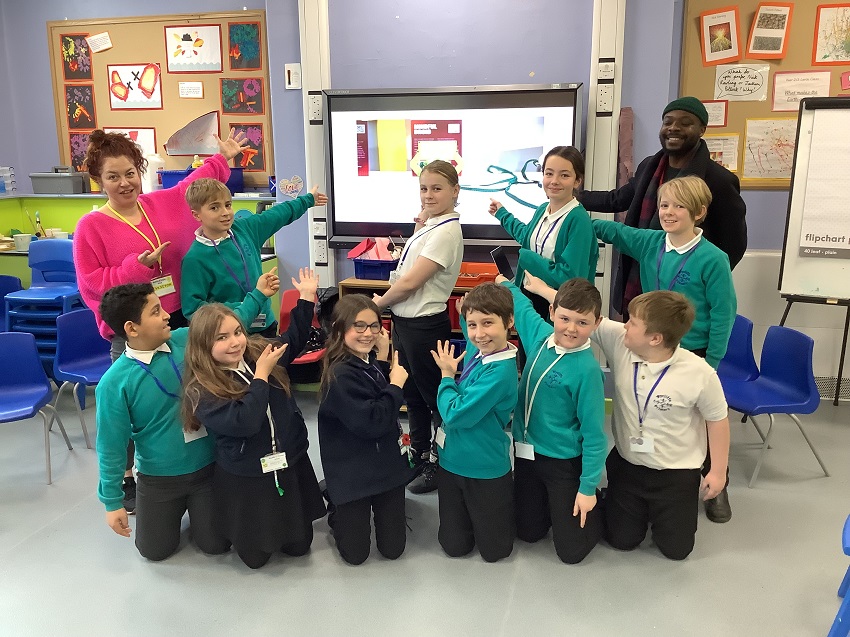 Wycliffe CE Primary School are standing in front of a screen and pointing at it.